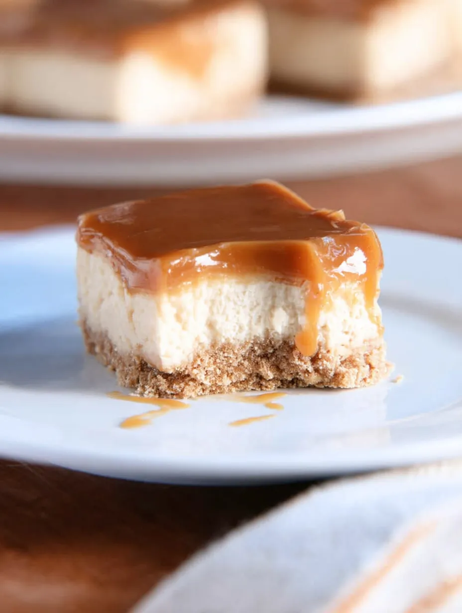 A slice of cheesecake with caramel sauce on a white plate.