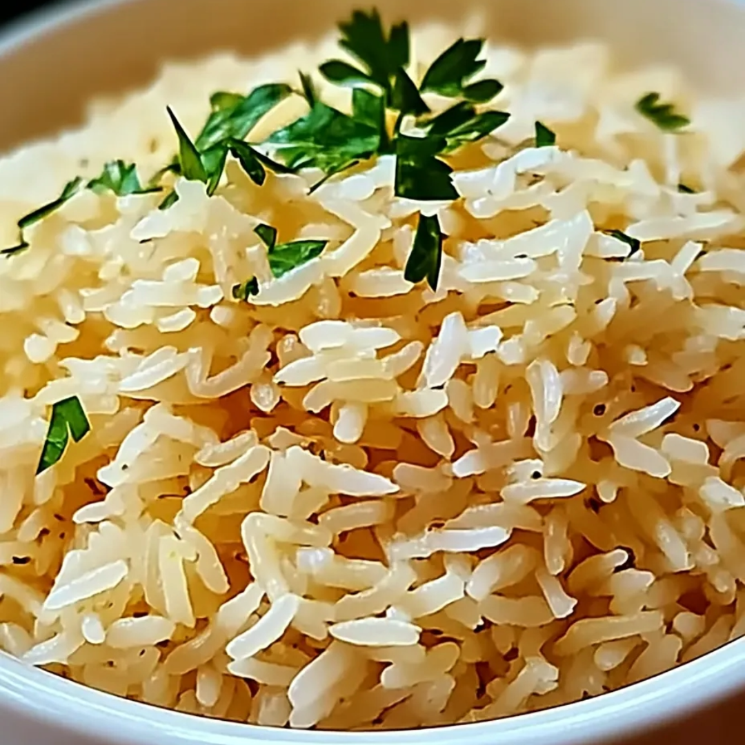 A bowl of rice with green herbs on top.