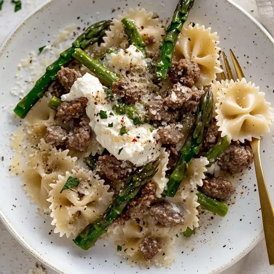 A plate of pasta with meat and cheese on top.