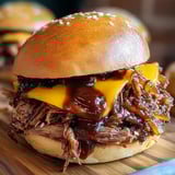 A close up of a sandwich with BBQ sauce.
