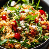 A bowl of quinoa with veggies and cheese.