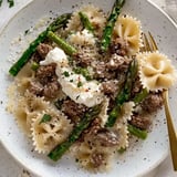 A plate of pasta with meat and cheese on top.