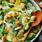 A bowl of salad with croutons and cheese.