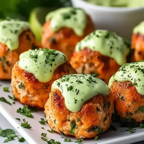 A plate of meatballs with sauce on top.