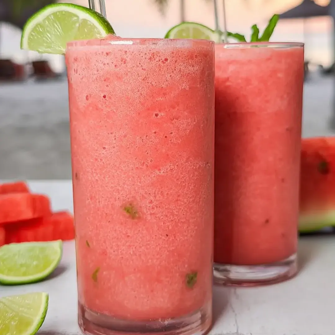 Two tall glasses with a bright pink smoothie.