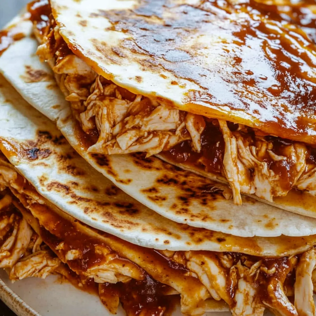 Quesadilla wedges stacked up with dipping sauce on the side.