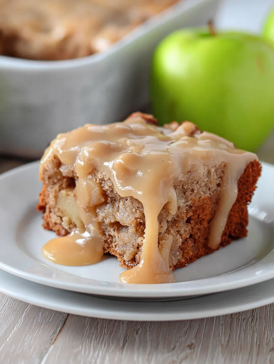 A slice of cake with caramel sauce on a white plate.