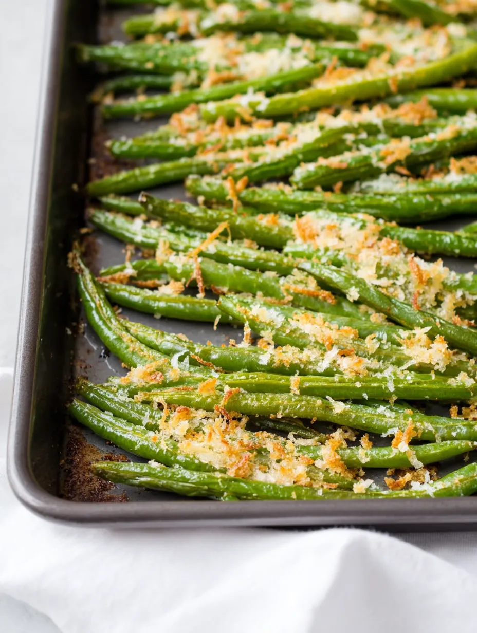 A pan of green beans with cheese on top.