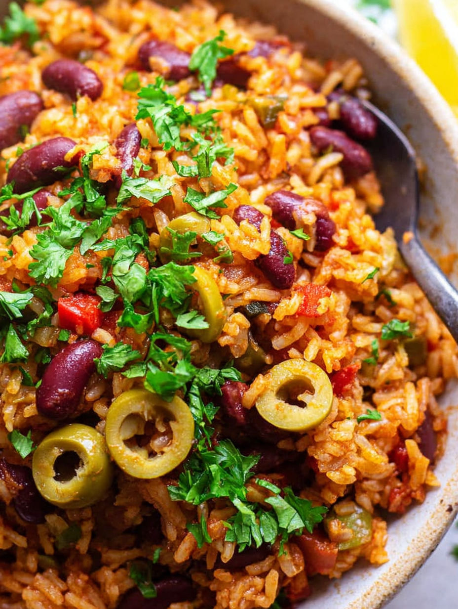 A bowl of rice and beans with green onions on top.