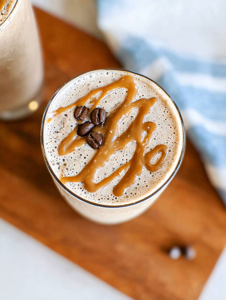 A glass of coffee smoothie with caramel drizzle.