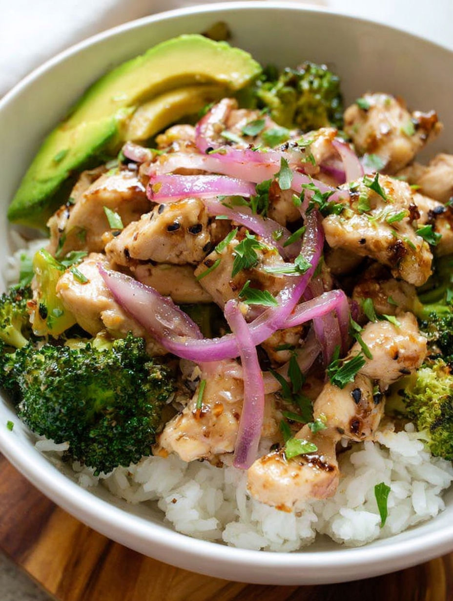 A bowl of chicken and broccoli with a side of rice.