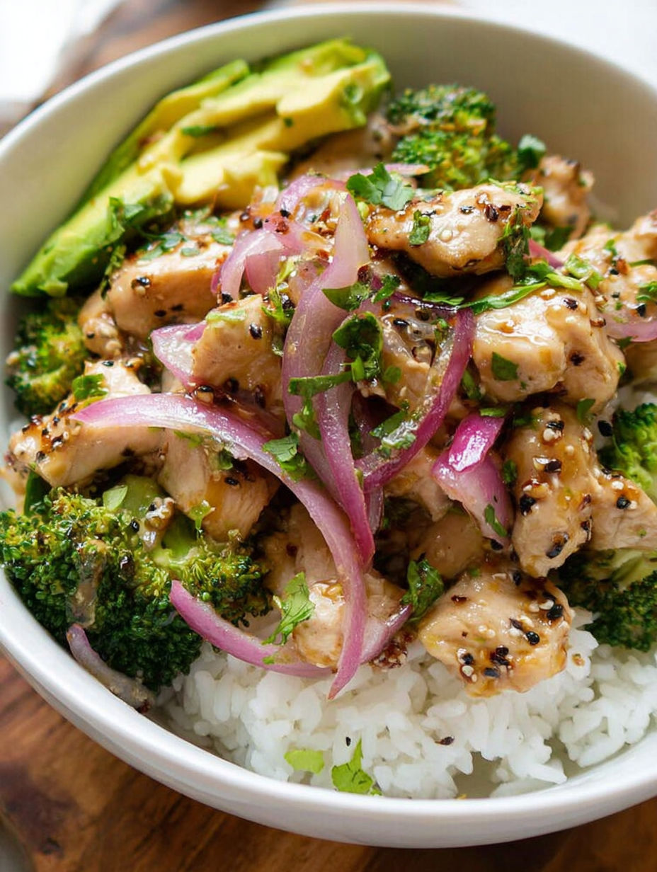 A bowl of chicken with onions and broccoli.