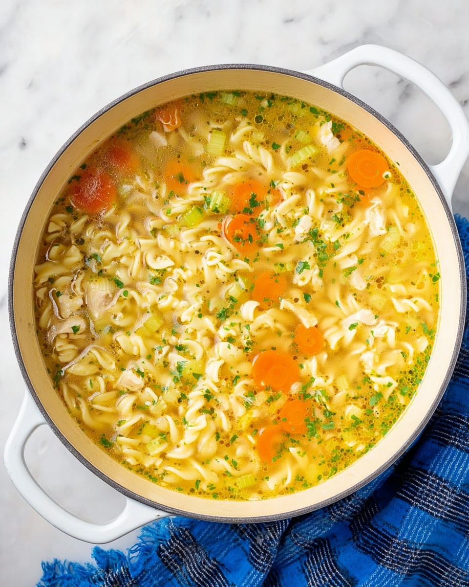 A bowl of noodles with vegetables and chicken.