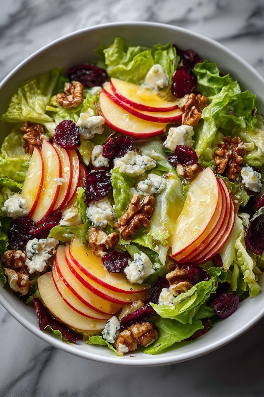 A bowl of salad with apples and feta cheese.
