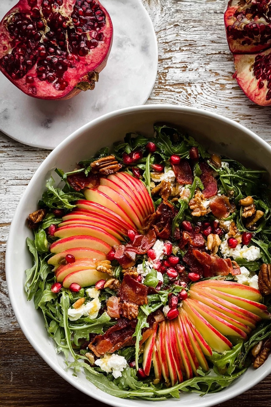 A bowl of salad with a slice of apple on top.