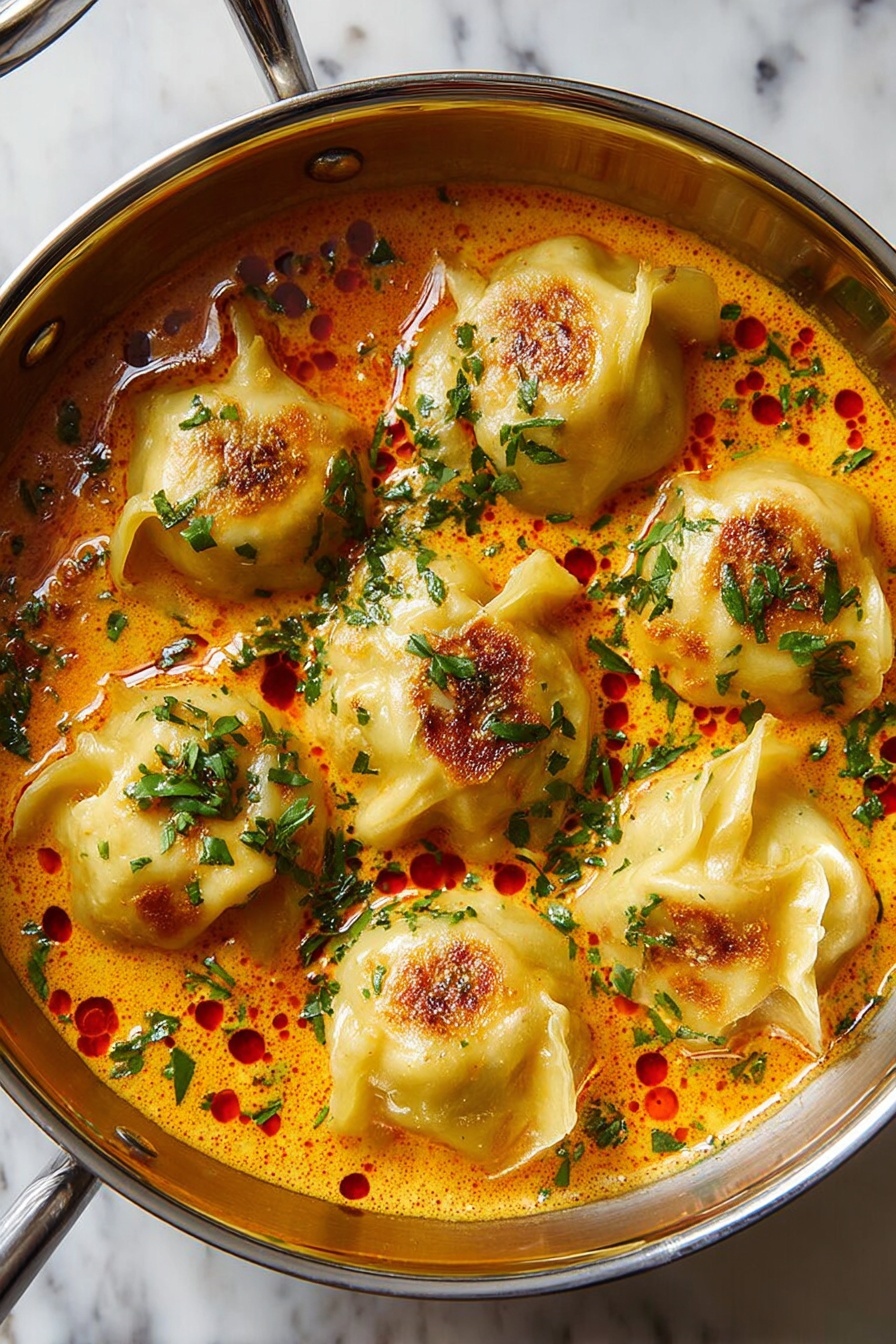 A bowl of soup with dumplings and vegetables.