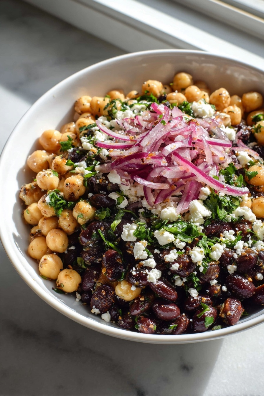 A bowl of food with chickpeas, onions, and feta cheese.