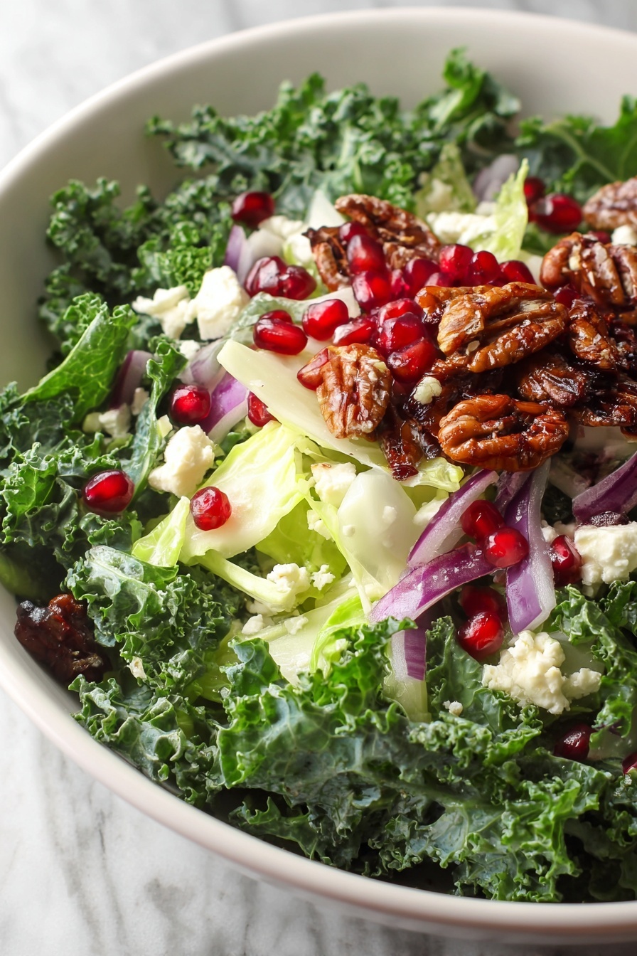 A bowl of salad with pomegranate seeds and walnuts.
