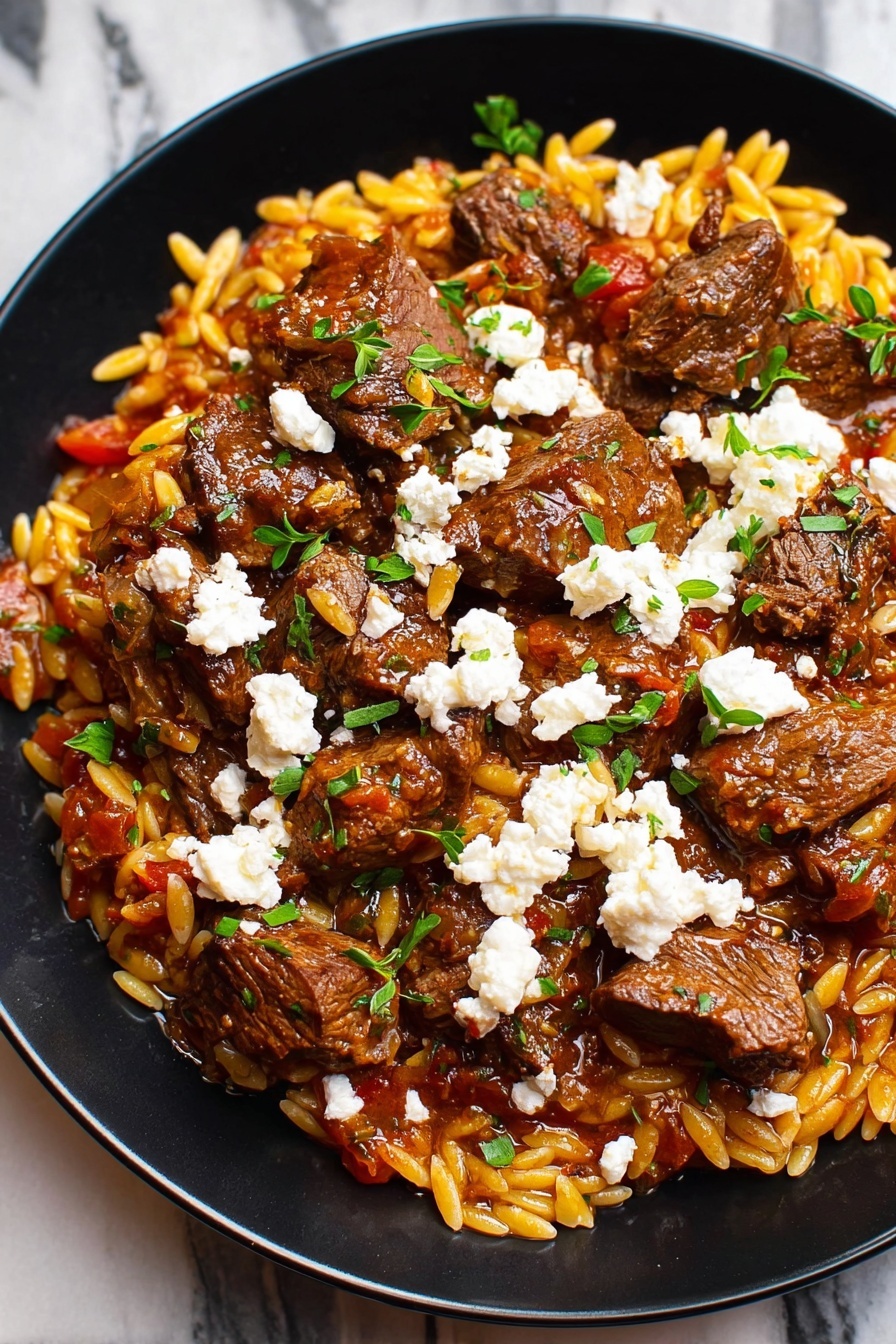 A plate of beef giouvetsi with rice and cheese.