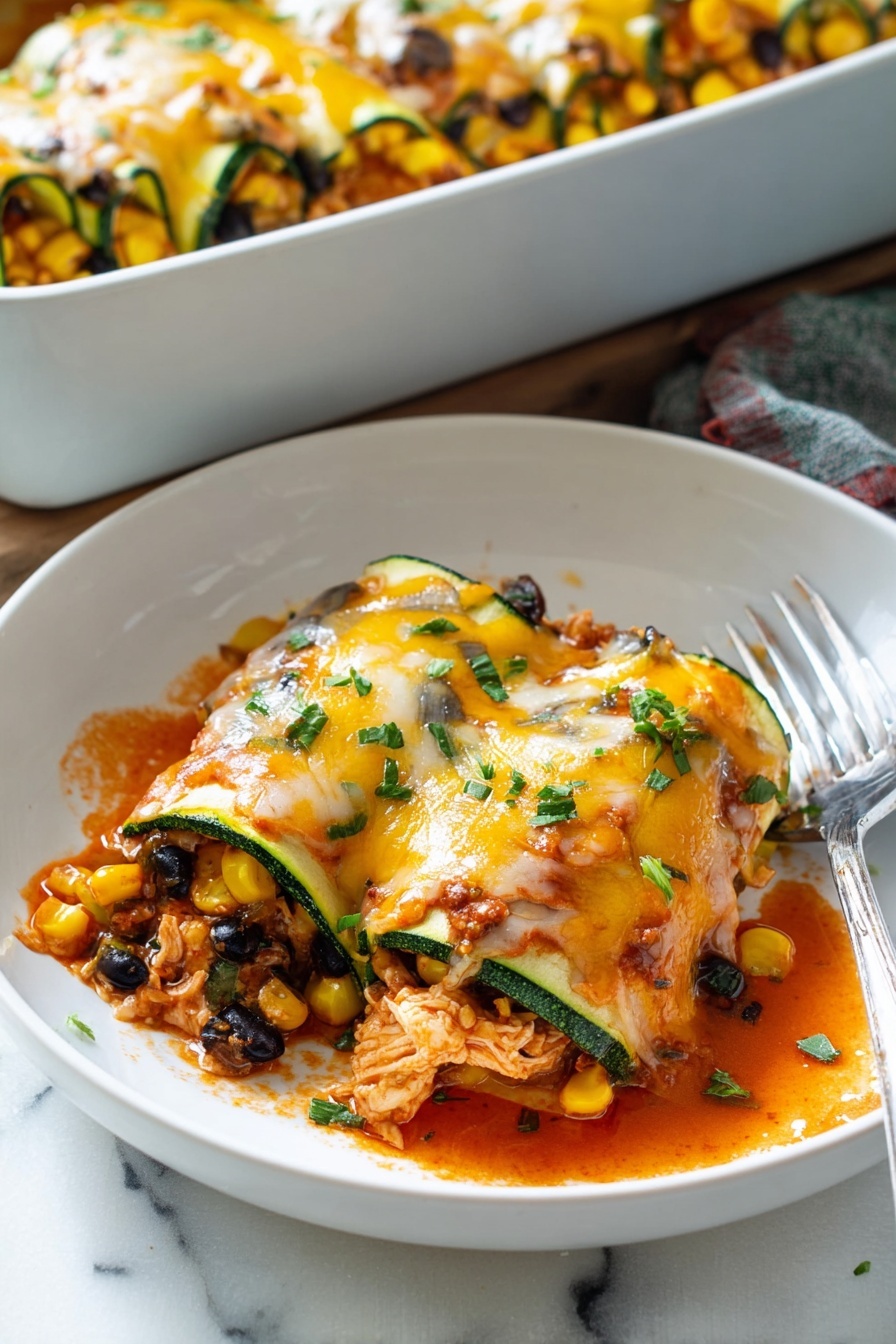 A zucchini enchilada roll up on a plate.