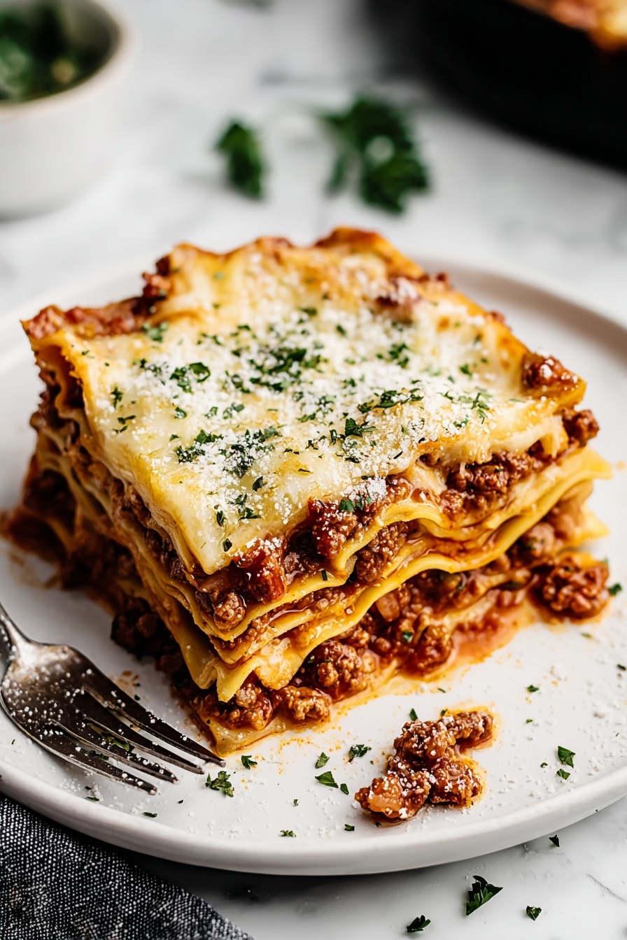 A plate of lasagna with cheese and meat on top.