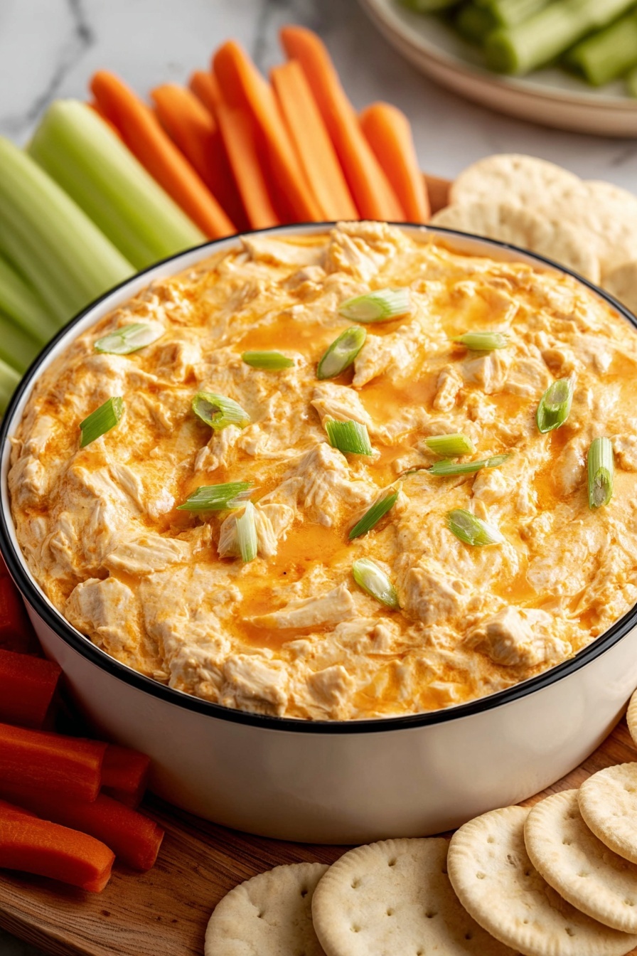 A bowl of dip with a green garnish.