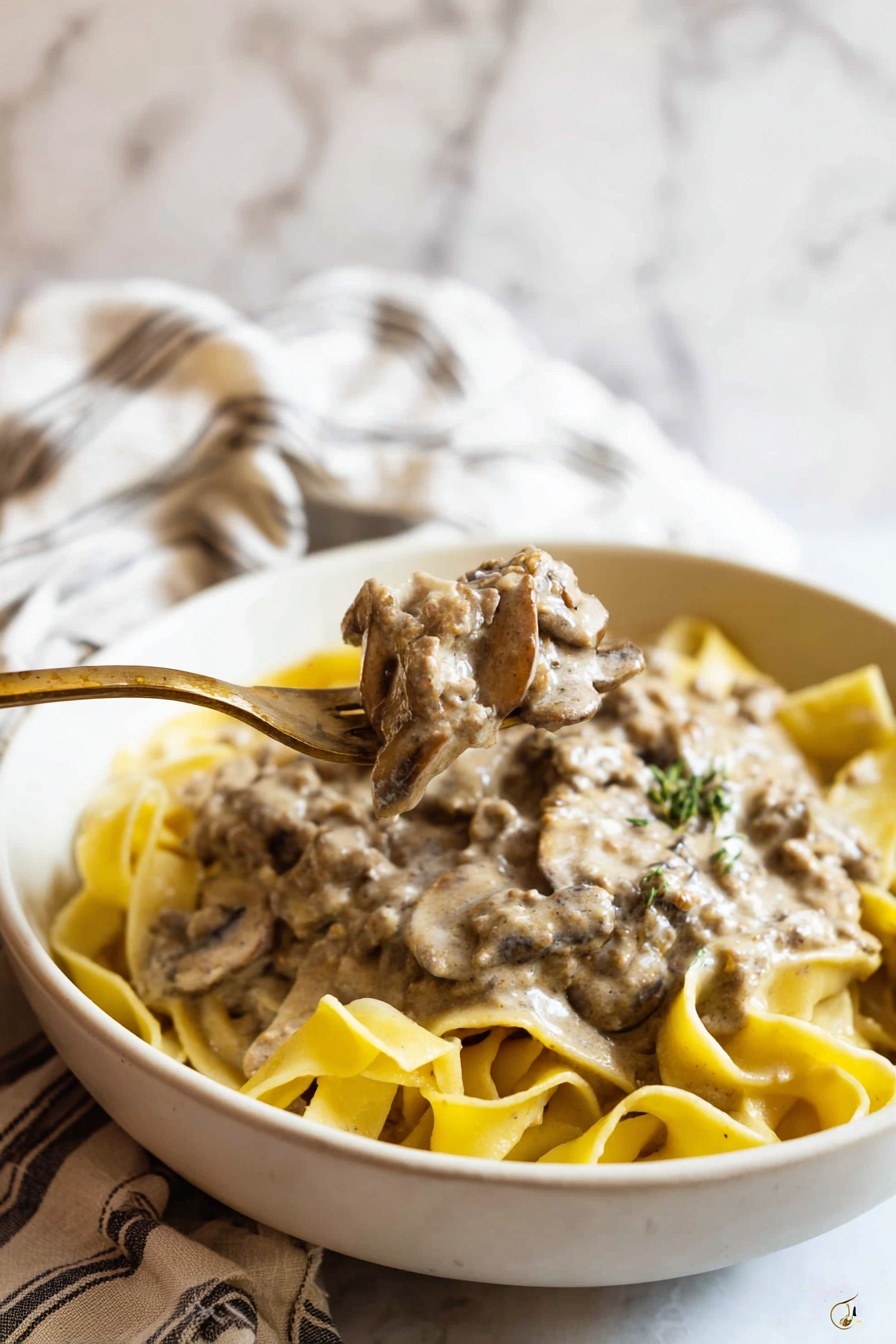 A bowl of bison stroganoff with a fork in it.