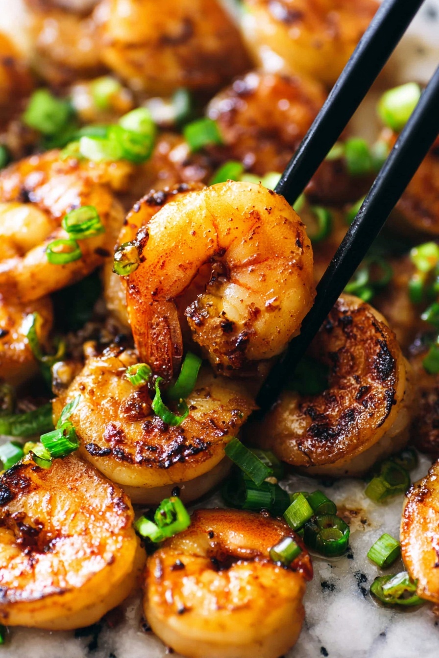 A plate of Peking Shrimp with chopsticks.