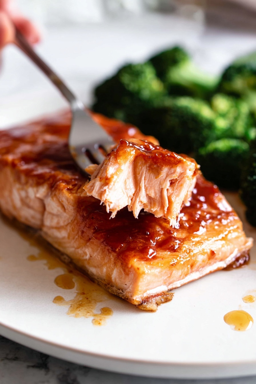 A piece of salmon with gochujang sauce on a plate.