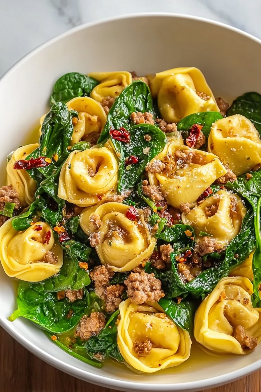 A bowl of pasta with meat and greens.