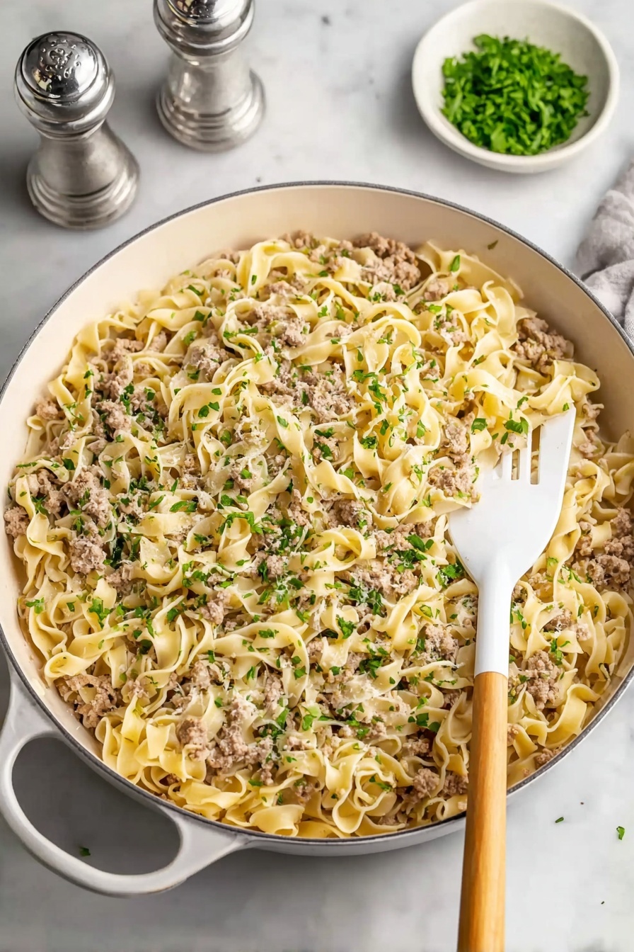 A bowl of pasta with meat and vegetables.