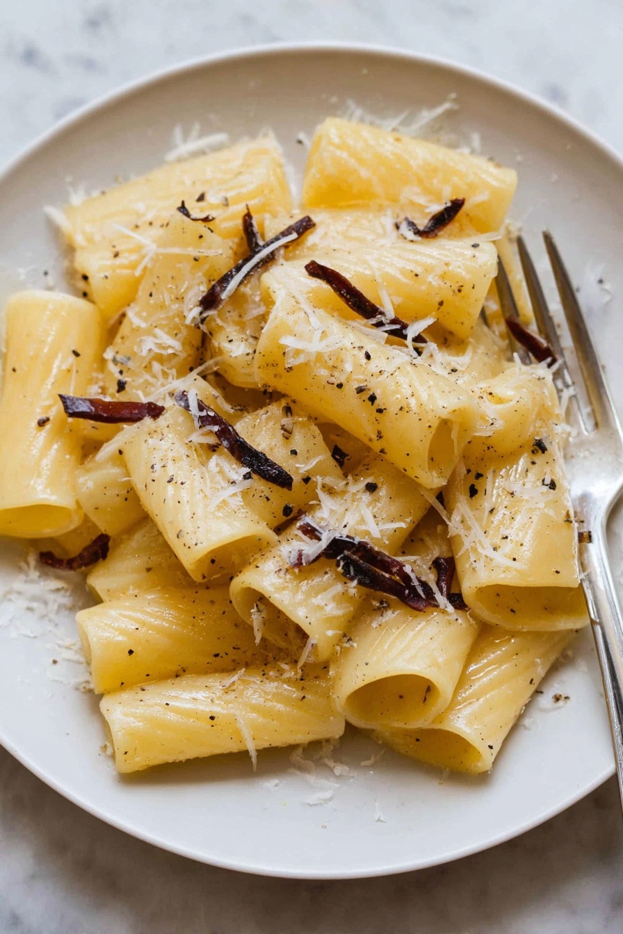 A plate of pasta with cheese and anchovies.