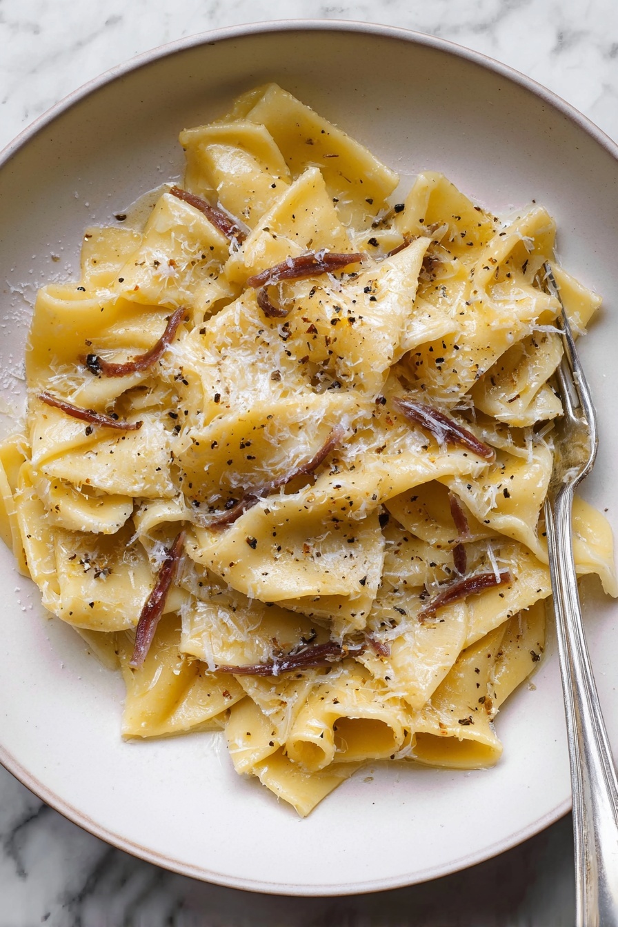 A plate of pasta with cheese and herbs.