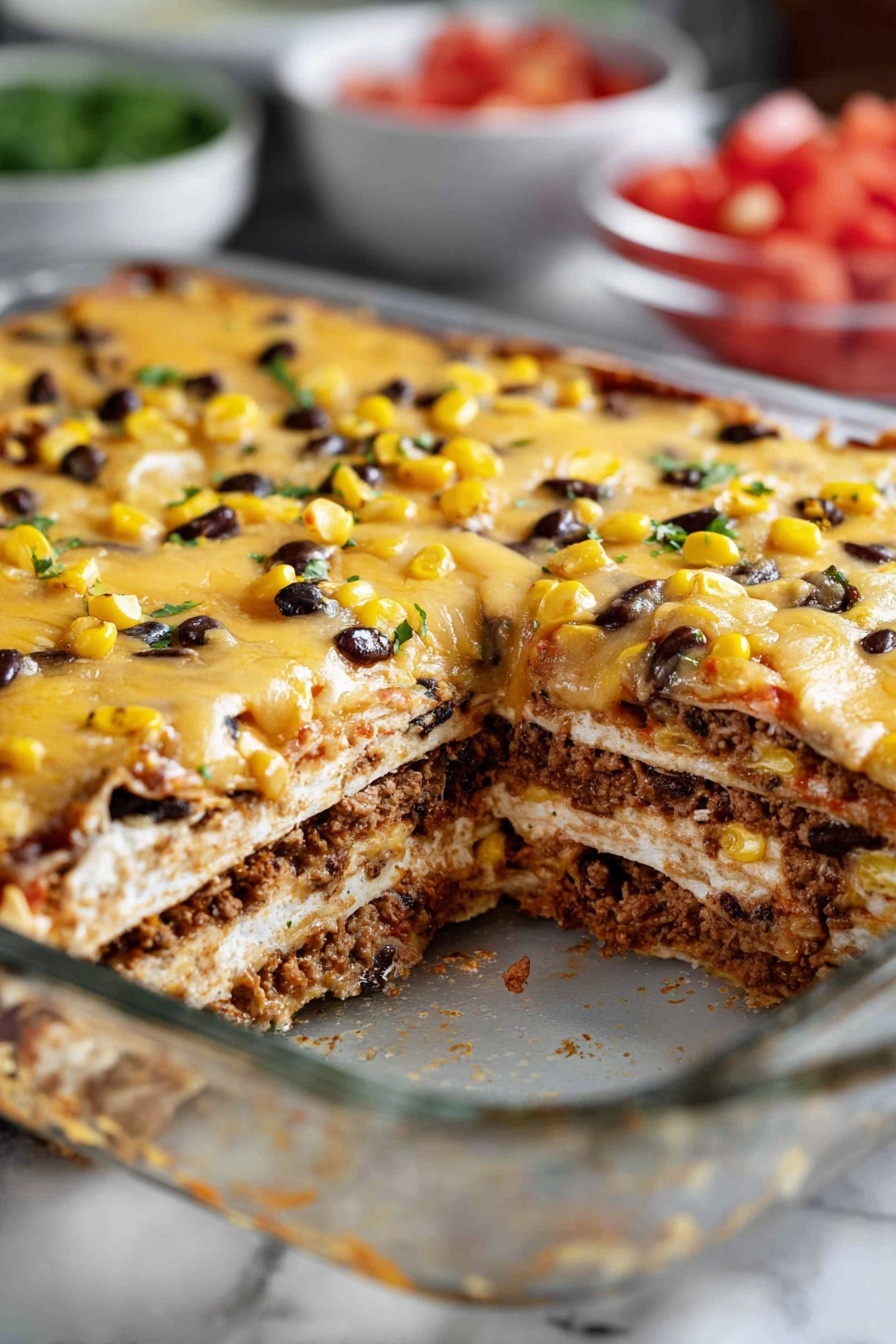 A vegan enchilada casserole is sliced and ready to be served.