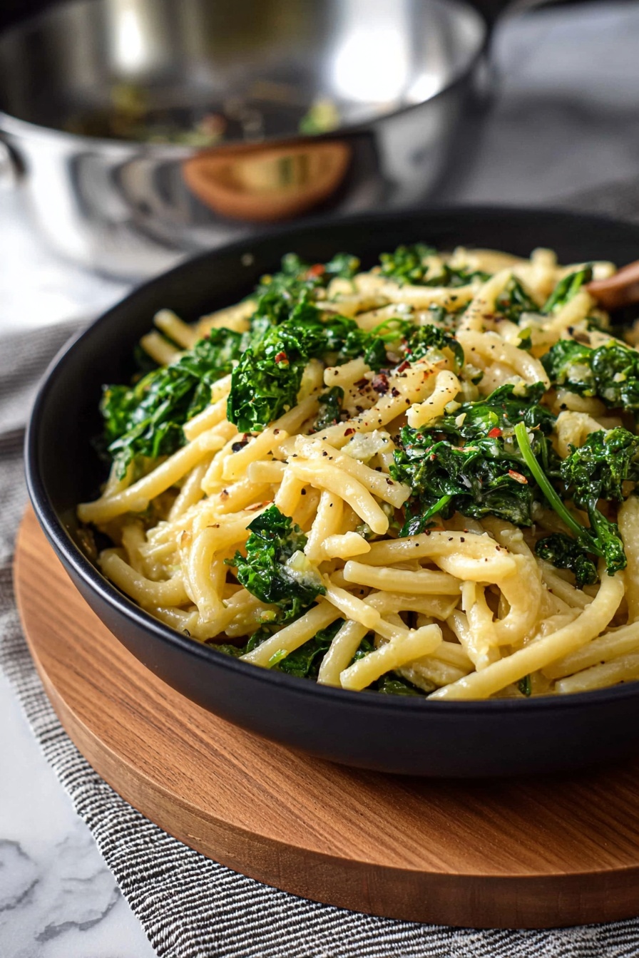 A bowl of pasta with broccoli and cheese.