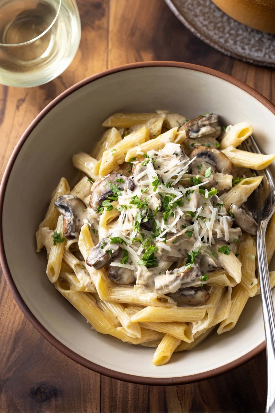 A bowl of pasta with mushrooms and cheese.