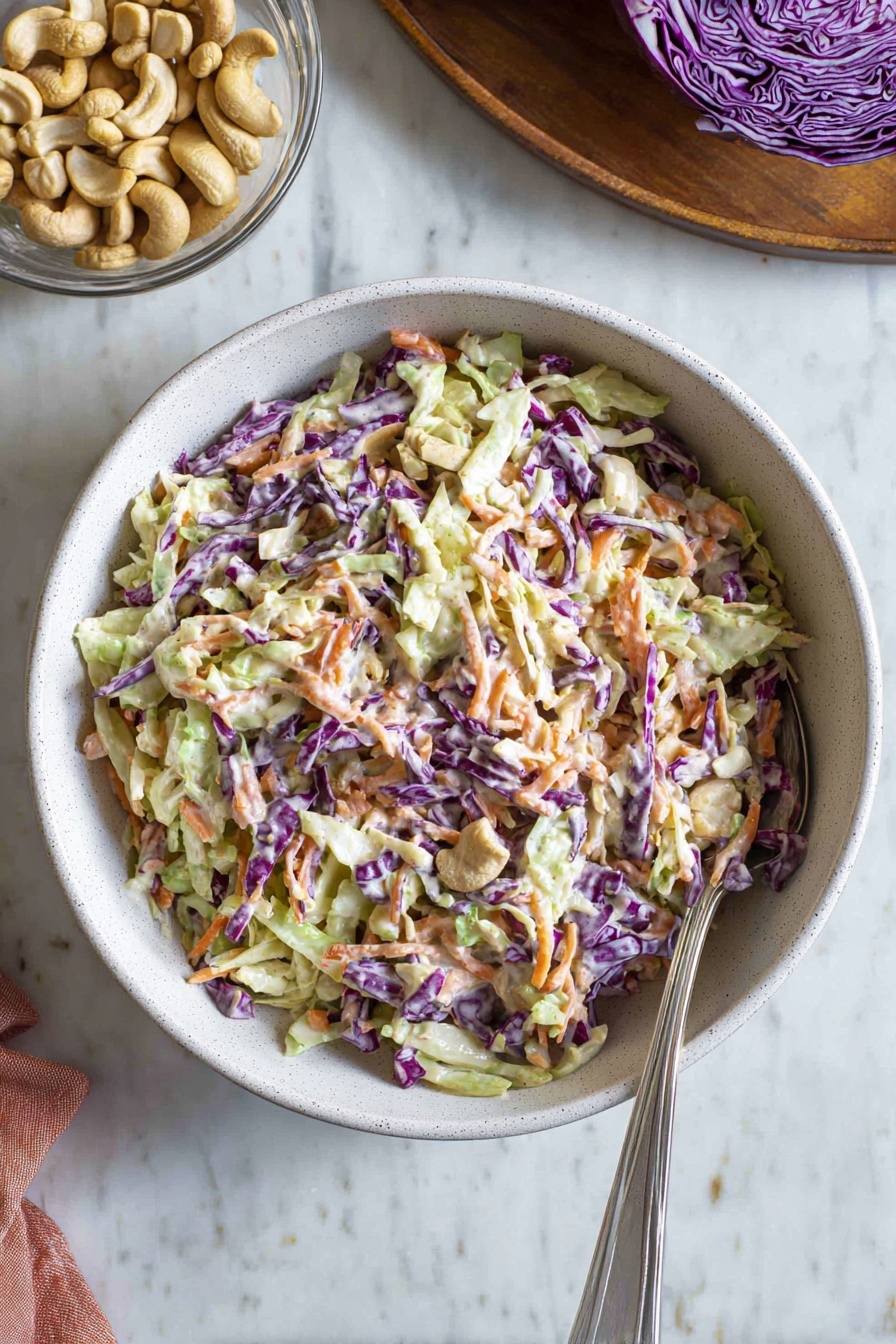 A bowl of coleslaw with a spoon in it.