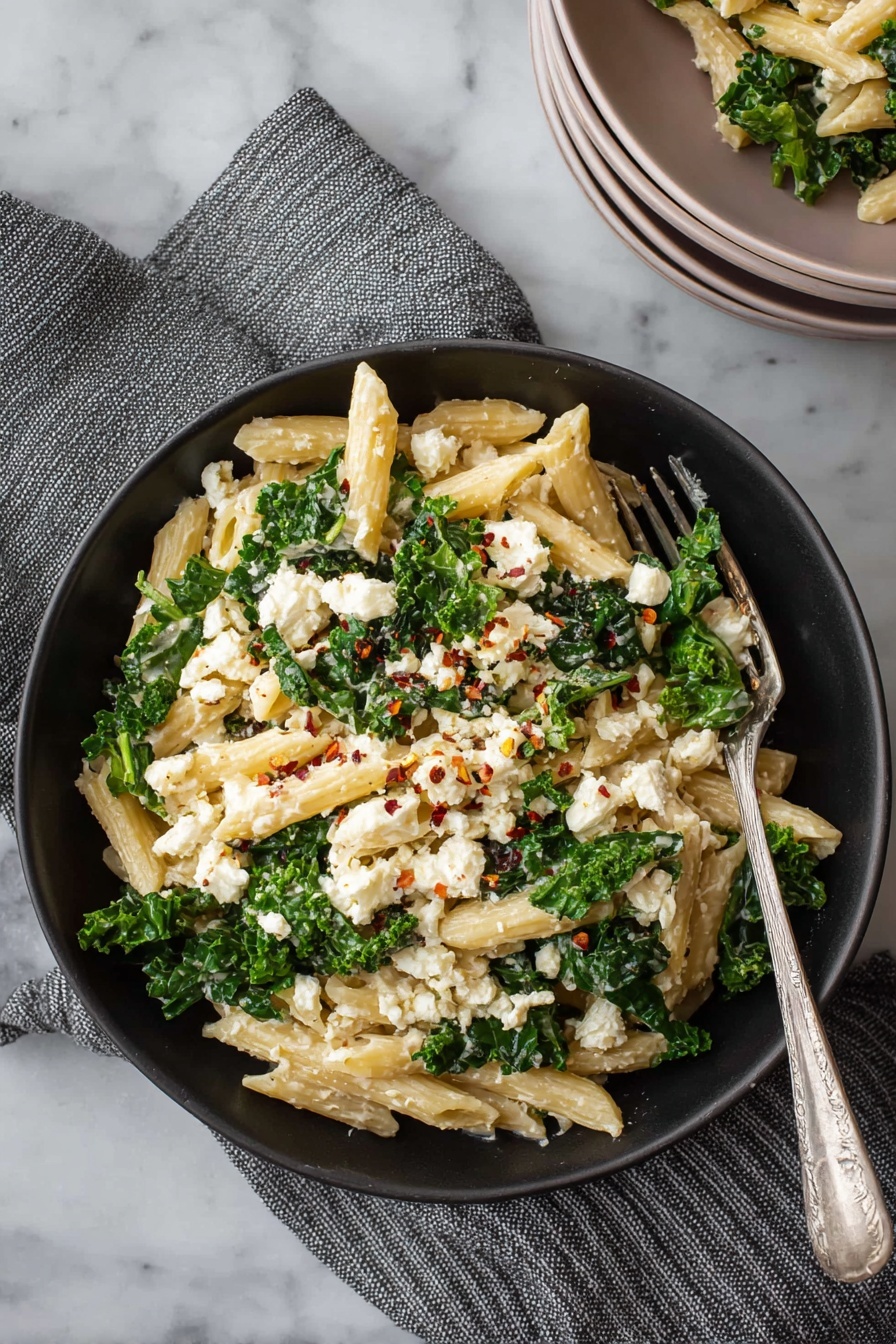 A bowl of pasta with cheese and spinach.