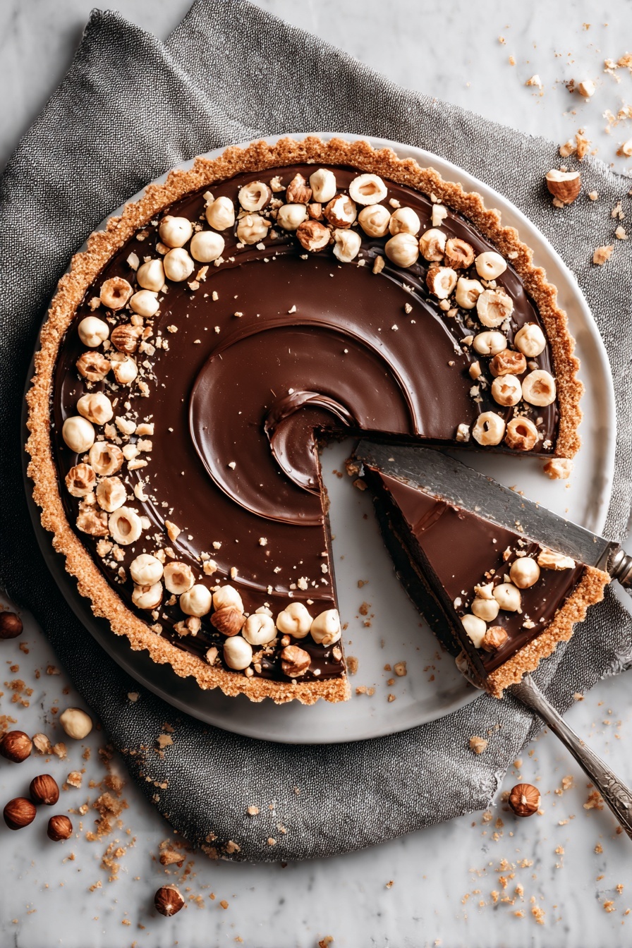 A slice of Nutella tart with a toasted hazelnut crust.
