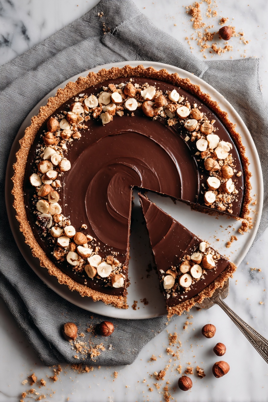 A slice of Nutella tart with toasted hazelnut crust.
