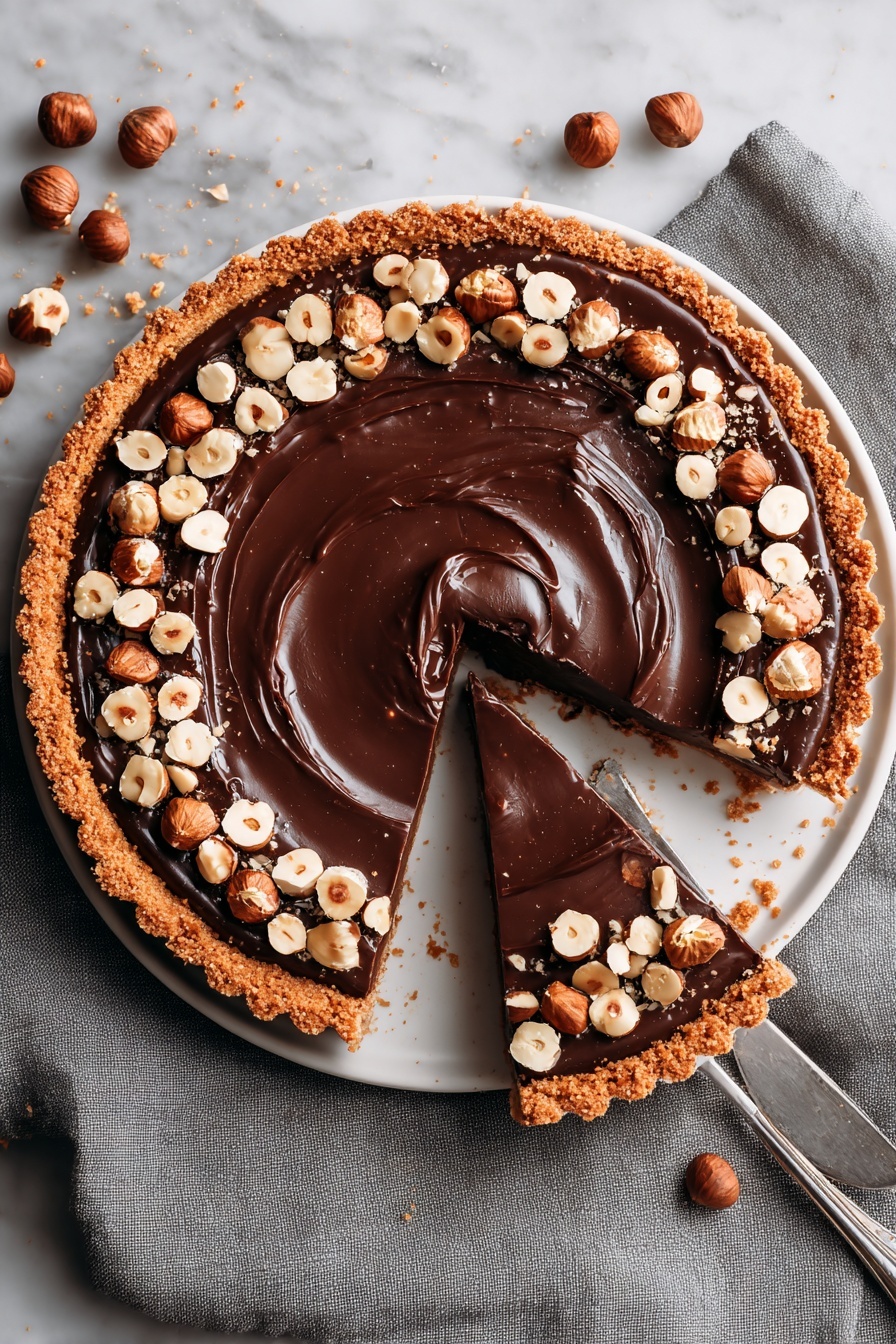 A slice of Nutella tart with a toasted hazelnut crust.