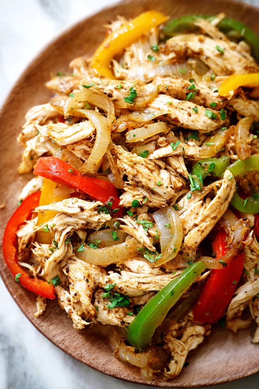 A plate of chicken with peppers and onions.
