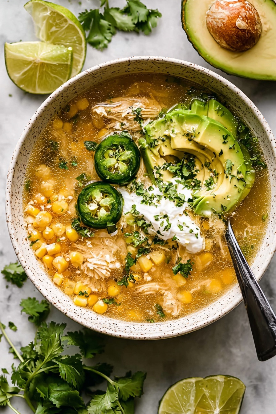 A bowl of chili with avocado and lime.
