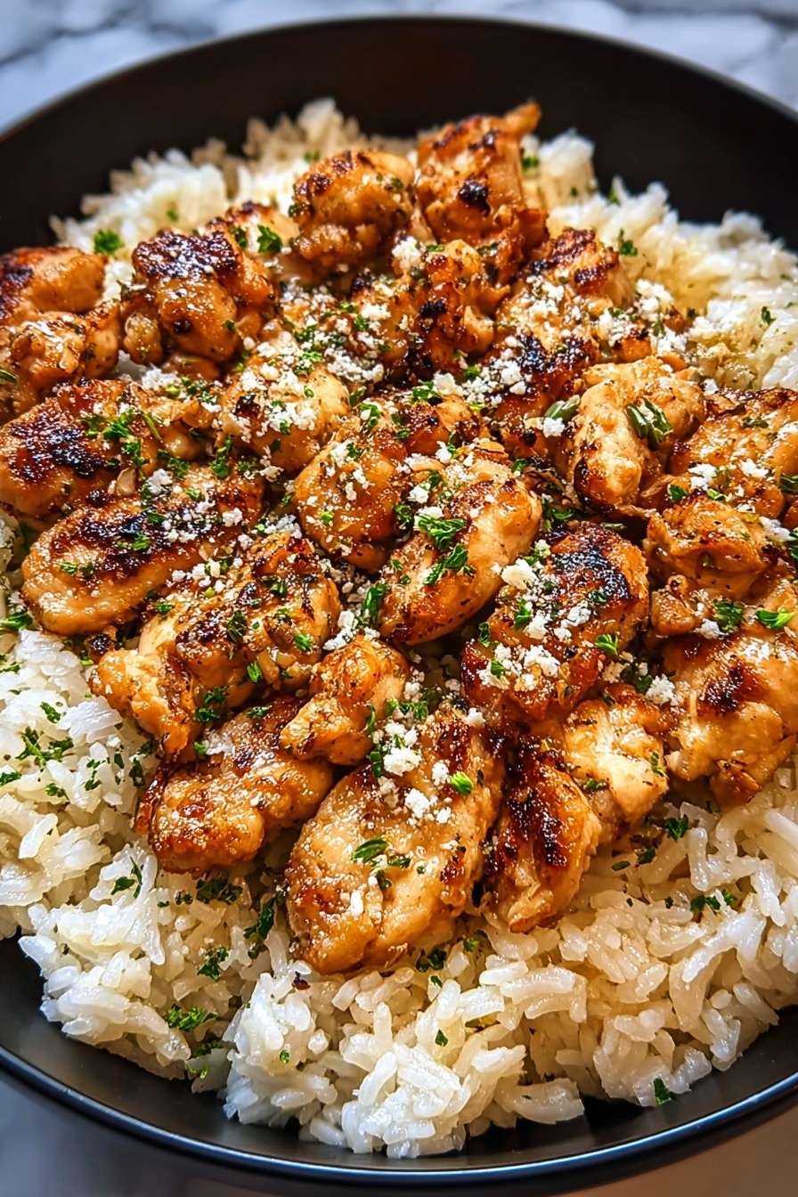A plate of rice with chicken and garlic parmesan.