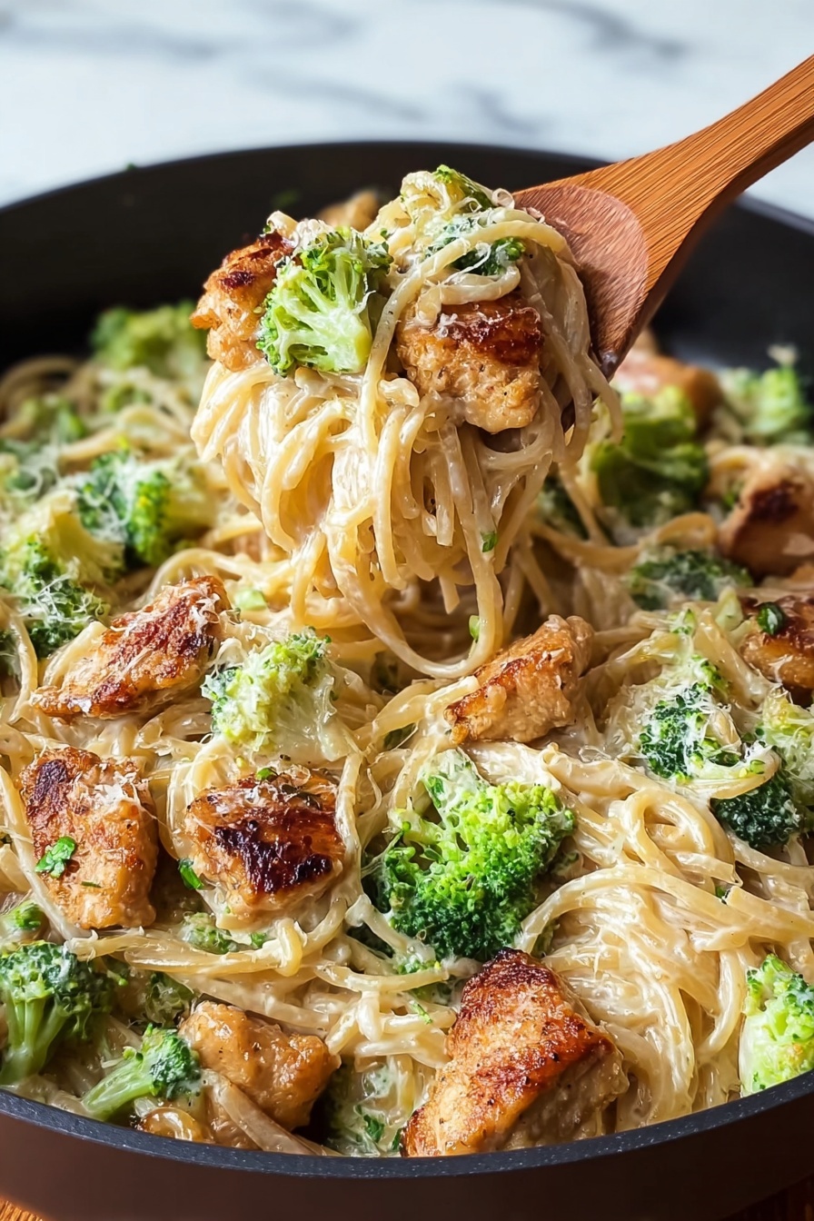 A close up of a bowl of pasta with broccoli and chicken.