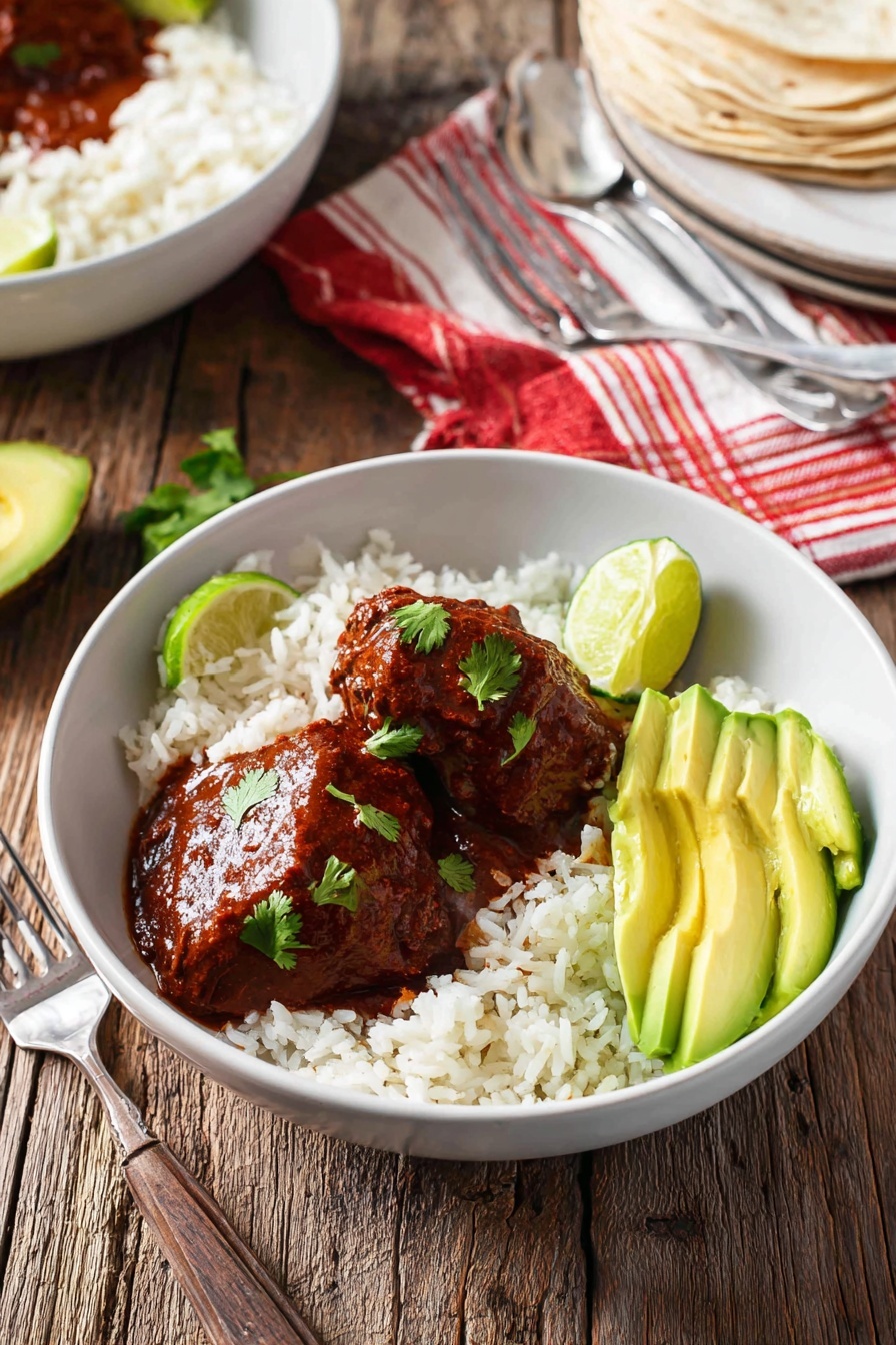 A bowl of Mexican chicken adobo with rice and avocado.
