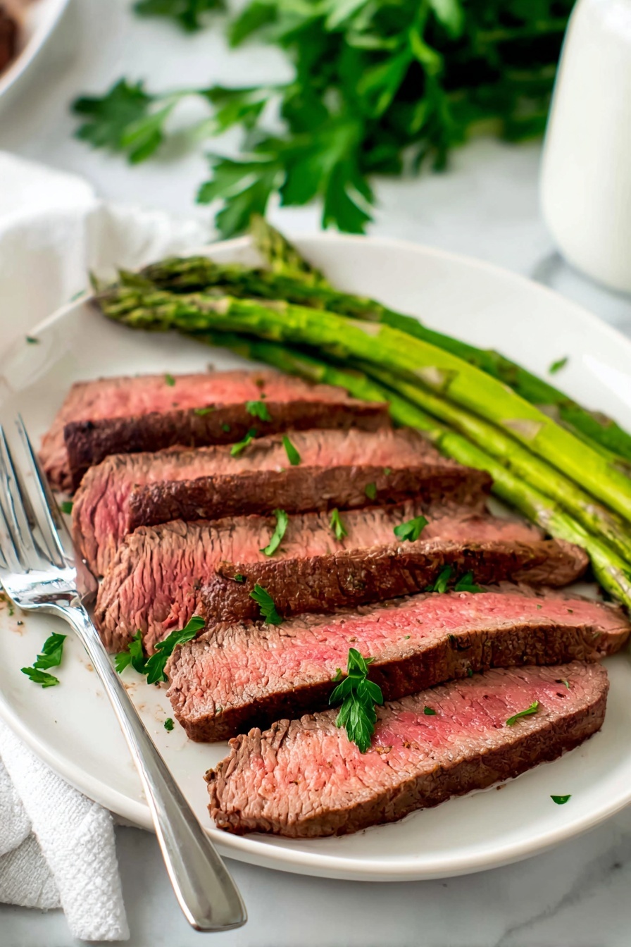 A plate of steak with green vegetables.