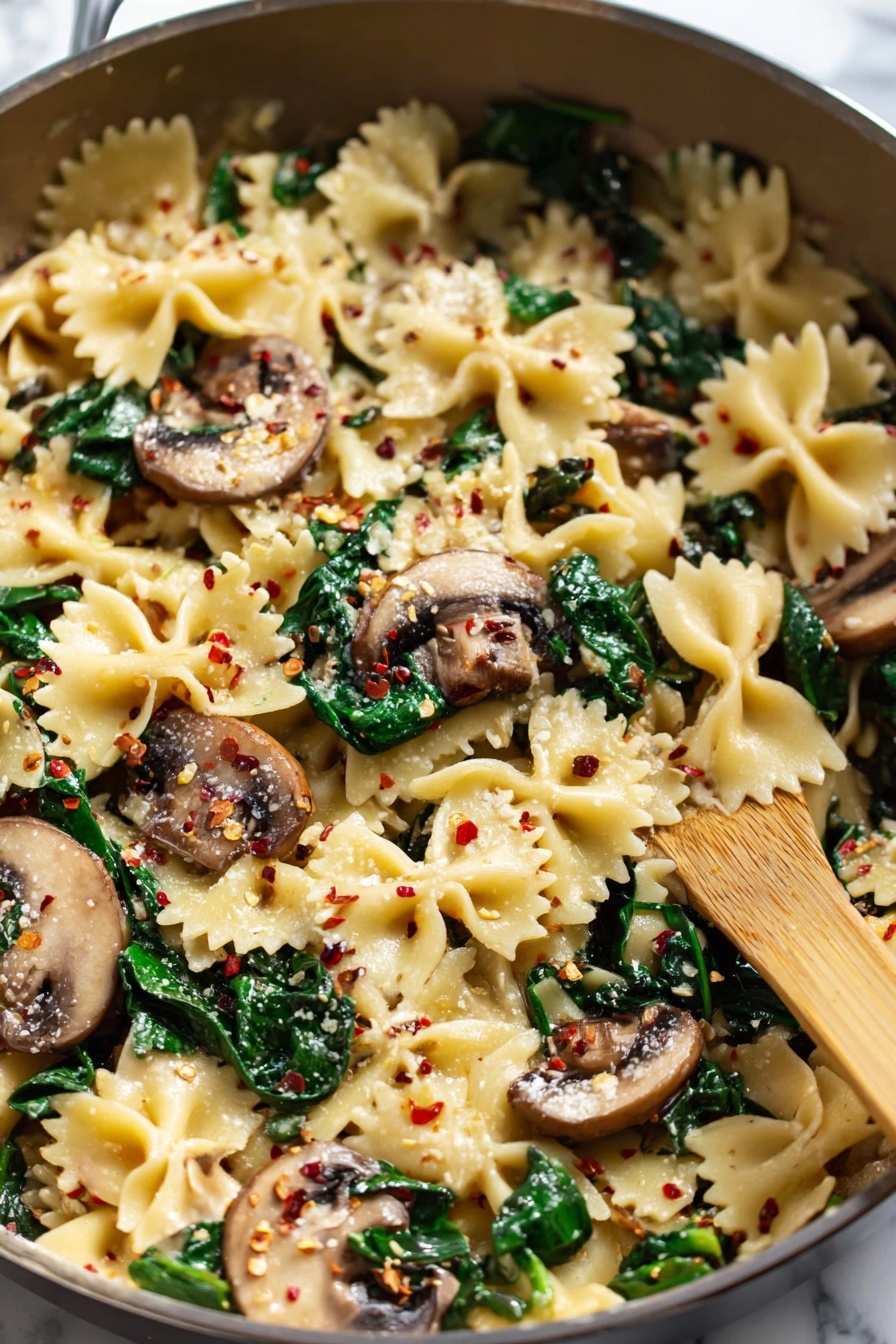 A dish of mushroom and spinach pasta.