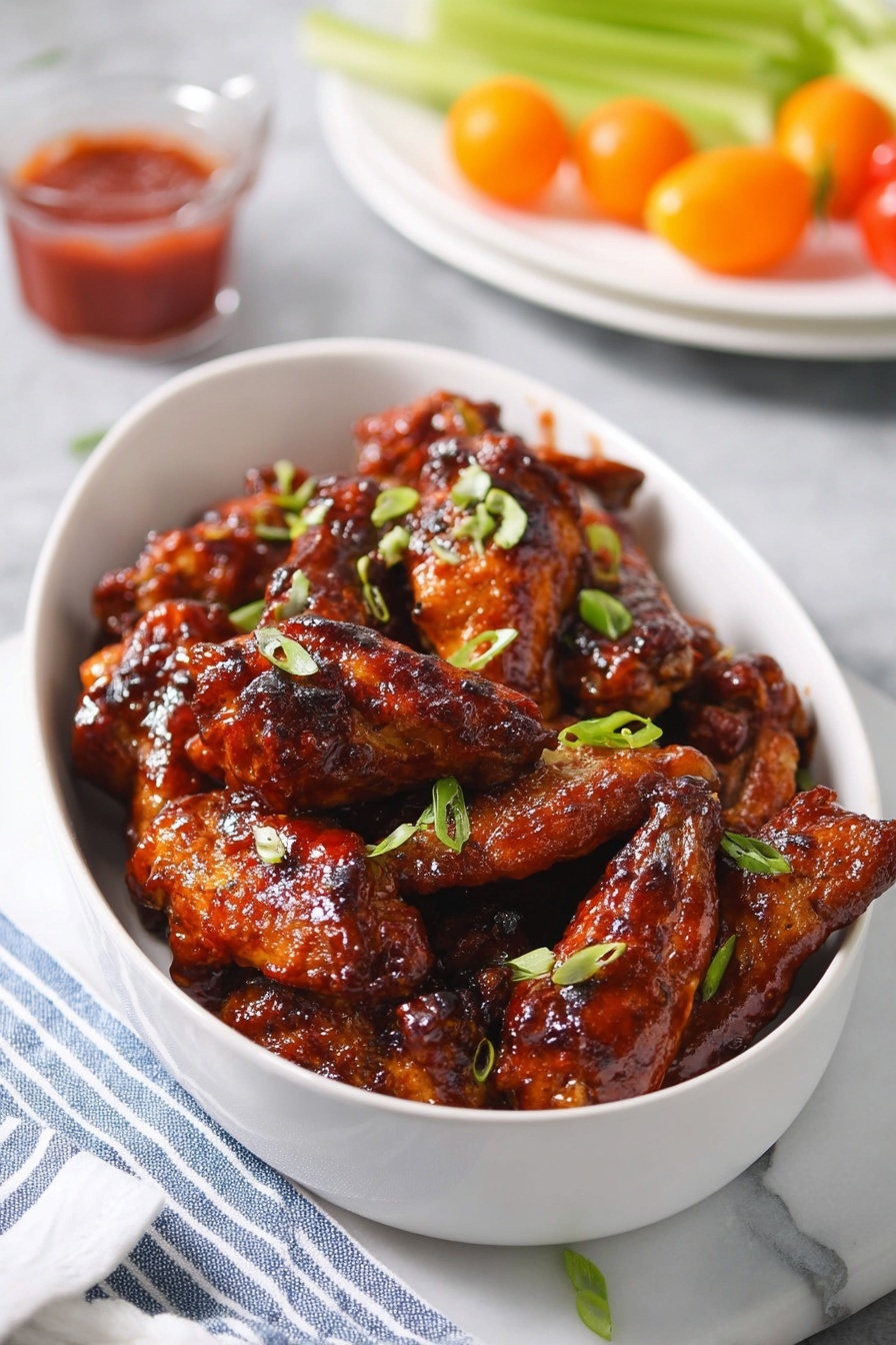 A bowl of chicken wings with barbecue sauce.