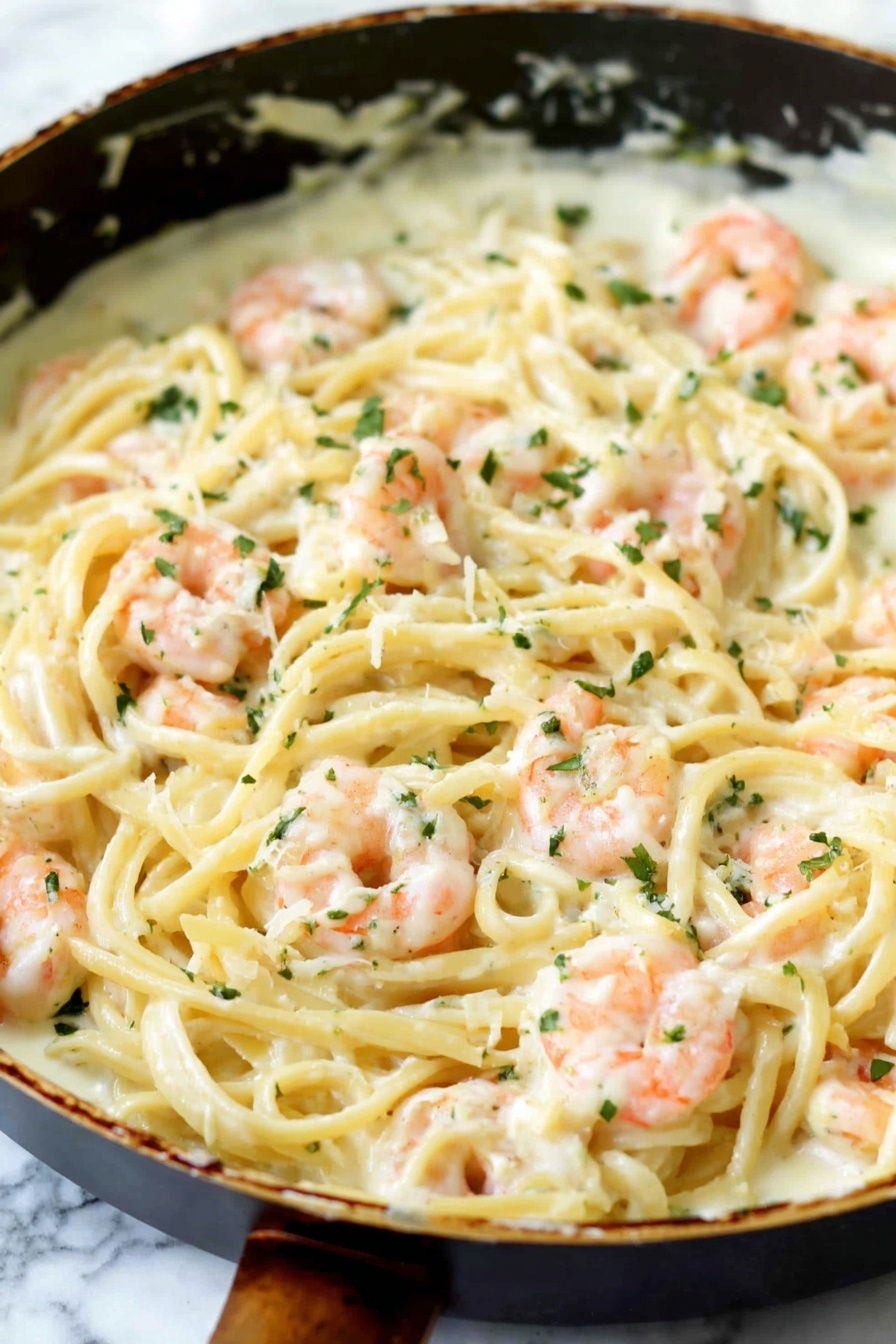A dish of shrimp alfredo with noodles and cheese.